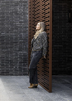 Interior designer Dana Oberson beside a wooden slatted wall