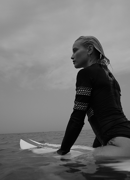 A woman sitting on a surfboard in the sea
